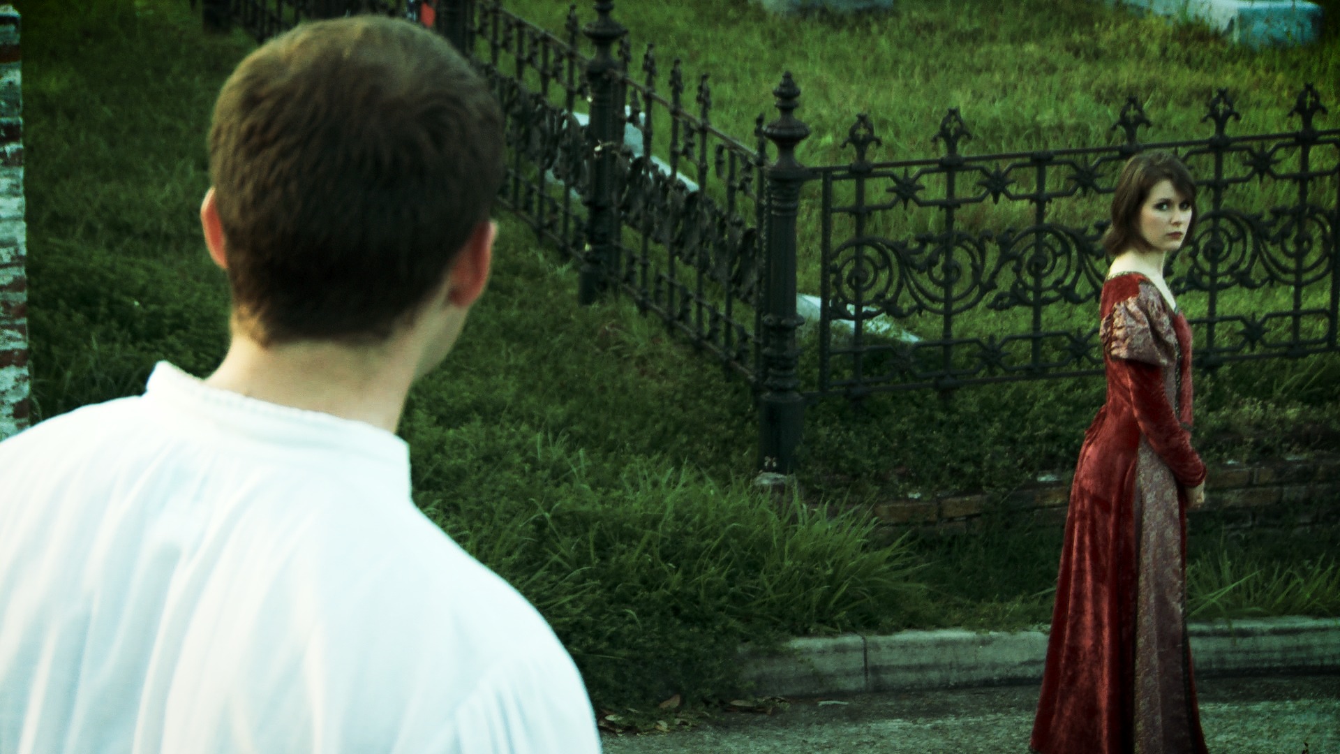 A young scholar catching first sight of a woman in red in a cemetery